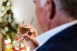 © Alvaro Sanchez/ADDICTIVE STOCK - Cropped unrecognizable male in festive outfit sitting with glass of champagne during Christmas celebration