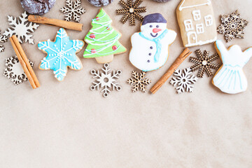  Gingerbread painted colored gingerbread cookies and spices and snowflakes on a craft background close-up. Christmas celebration concept. New Year's food. Copy space
