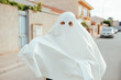 © Dani Navarro/ADDICTIVE STOCK - Unrecognizable kid in white ghost costume having fun on street during Halloween holiday and looking at camera