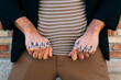 © David Munoz/ADDICTIVE STOCK - Crop unrecognizable male in stylish apparel demonstrating hands with tattoo near brick wall in town