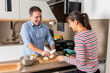 © Galdric Penarroja/ADDICTIVE STOCK - Happy smiling couple in casual clothes standing near kitchen counter and cutting onion while cooking lunch together