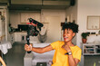 © Jake Jakab/ADDICTIVE STOCK - Cheerful young African American female blogger recording video while preparing content for social networks at home