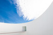 © Javier Bravo/ADDICTIVE STOCK - Low angle white minimalist building wall in futuristic style with narrow inclined ramp located under blue sky