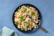 © Katerina Solovyeva/ADDICTIVE STOCK - Vegan rice with vegetables, healthy and delicious, the plate is shot from above on a blue background