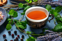 Herbal Tea, Natural, Organic, And Healthy, A Tea Cup With An Assortment Of Ingredients On A Blue Background