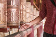© Luis Gomez/ADDICTIVE STOCK - Full body of Asian female passing by Tibetan rolls with ancient prayer near sacred oriental temple