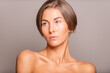 © Sebastian Candiolli/ADDICTIVE STOCK - Charming female model with short hair and bare shoulders standing on violet background in studio and looking away