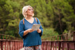 © Si And Si/ADDICTIVE STOCK - Adult female tourist holding map and looking away while standing on footbridge against green forest and searching for direction during travel in Spain