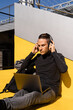 © En Clave Granate/ADDICTIVE STOCK - Serious young male entrepreneur wearing casual clothes using laptop and wireless headphones while working in park