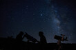 © Gabriel Trujillo/ADDICTIVE STOCK - Silhouettes of anonymous scientists using telescopes while exploring night starry sky with milky way in darkness