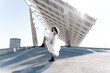 © joan corominas/ADDICTIVE STOCK - Full body of cool bride in brutal boots dancing looking at camera on paved waterfront with solar batteries on background in back