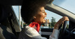© Jose Carlos Cerdeno/ADDICTIVE STOCK - Side view of African American female driver driving automobile and laughing happily with eyes closed