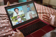 © Juan Alberto Ruiz/ADDICTIVE STOCK - From above crop anonymous female sitting on bed and communicating with multiracial friends via video chat on laptop while staying at home during coronavirus pandemic
