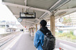 © Luis Manuel Munoz/ADDICTIVE STOCK - Back view of ethnic male tourist in mask and with backpack standing on platform of railway station during coronavirus epidemic
