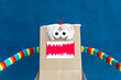 © Sergio Victor Vega/ADDICTIVE STOCK - Unrecognizable playful kid wearing funny costume of monster made of carton box standing on street during holiday celebration