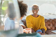 © Philippe Degroote/ADDICTIVE STOCK - African American female with short hair speaking to unrecognizable friend with curly hair sitting on terrace and talking laughing at jokes and looking at each other while drinking hot beverage