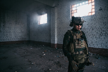 A thoughtful soldier, resting from a military operation while it is raining outside.