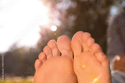 Man sitting barefoot outdoors on sunny day, closeup Canvas