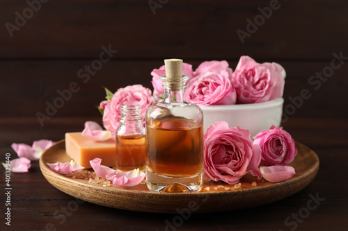 Composition with aroma oil and flowers on wooden table Fototapet
