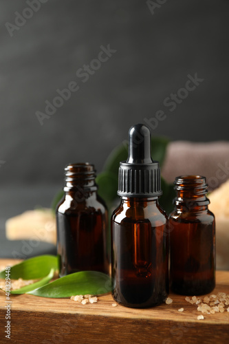 Fotografering Composition with aroma oil bottles on wooden board, closeup