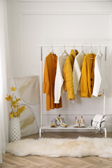 Poster - Rack with stylish warm clothes, shoes and accessories in modern dressing room