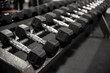 A rack of rubberized hex dumbbells at a gym or fitness club. Workout and pyramid training or running the rack concept.
