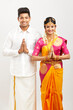 Attractive south Indian couple greeting namaste in traditional dress.