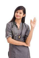 Wall Mural - Attractive smiling young Indian female doctor showing hand sign on white.