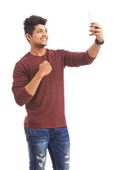 Wall Mural - Attractive Indian young man taking selfie in mobile phone on white.