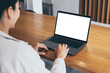 © panitan - computer screen blank mockup.hand woman work using laptop with white background for advertising,contact business search information on desk at coffee shop.marketing and creative design