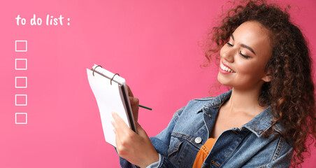 Young African-American woman with notebook and to do list on color background