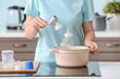 © Pixel-Shot - Woman cleaning baby bottle at home
