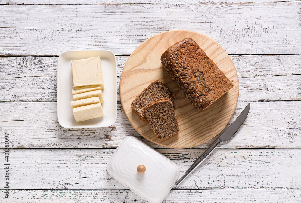 Fresh butter and tasty bread on wooden table