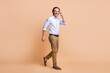 © deagreez - Full length photo of man step fingers hold eyewear wear specs shirt pants shoes isolated beige color background