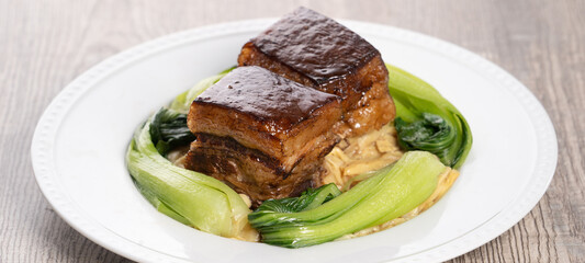 ong Po Pork meat in a blue plate with broccoli with red background.