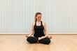 © Jordi Mora - woman sitting in yoga position and meditating isolated over parquet