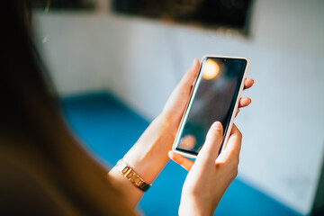 Selective focus on female hands holding cellphone technology for browsing internet website during leisure time, cropped image of unrecognizable blogger using smartphone for online networking