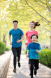© Blue Jean Images - Happy young family running in park