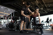 © Blue Jean Images - Young woman working out with personal trainer at gym