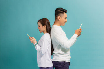 Wall Mural - Angry boyfriend and girlfriend ignoring each other and using phone after argument