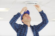 © auremar - electrician man are screw object on the ceiling