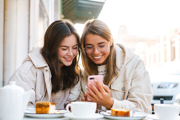 Wall Mural - Two young girls using smart phone