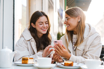 Wall Mural - Two young girls using smart phone