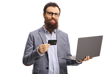 Wall Mural - Bearded man holding a credit card and a laptop computer