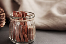 Cinnamon Sticks And Cubes Of Brown Sugar In Glass Jar On Grey And  Brown Background. Close Up. Copy Space