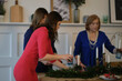 © yavdat - family have fun together on Christmas weekend. three women of different generations set the festive table together. relationship between generations. soft focus, selective focus