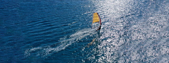 Aerial drone ultra wide photo of professional wind surfer practice in deep blue open ocean sea