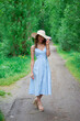 © евгений ставников - beautiful girl in a straw hat and blue dress on the road in the Park