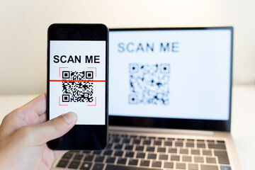 using a smartphone app to scan a qr code. man's hand uses a mobile phone application to scan qr code