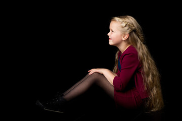 Wall Mural - Side view of happy smiling blonde girl. Isolated on black background.